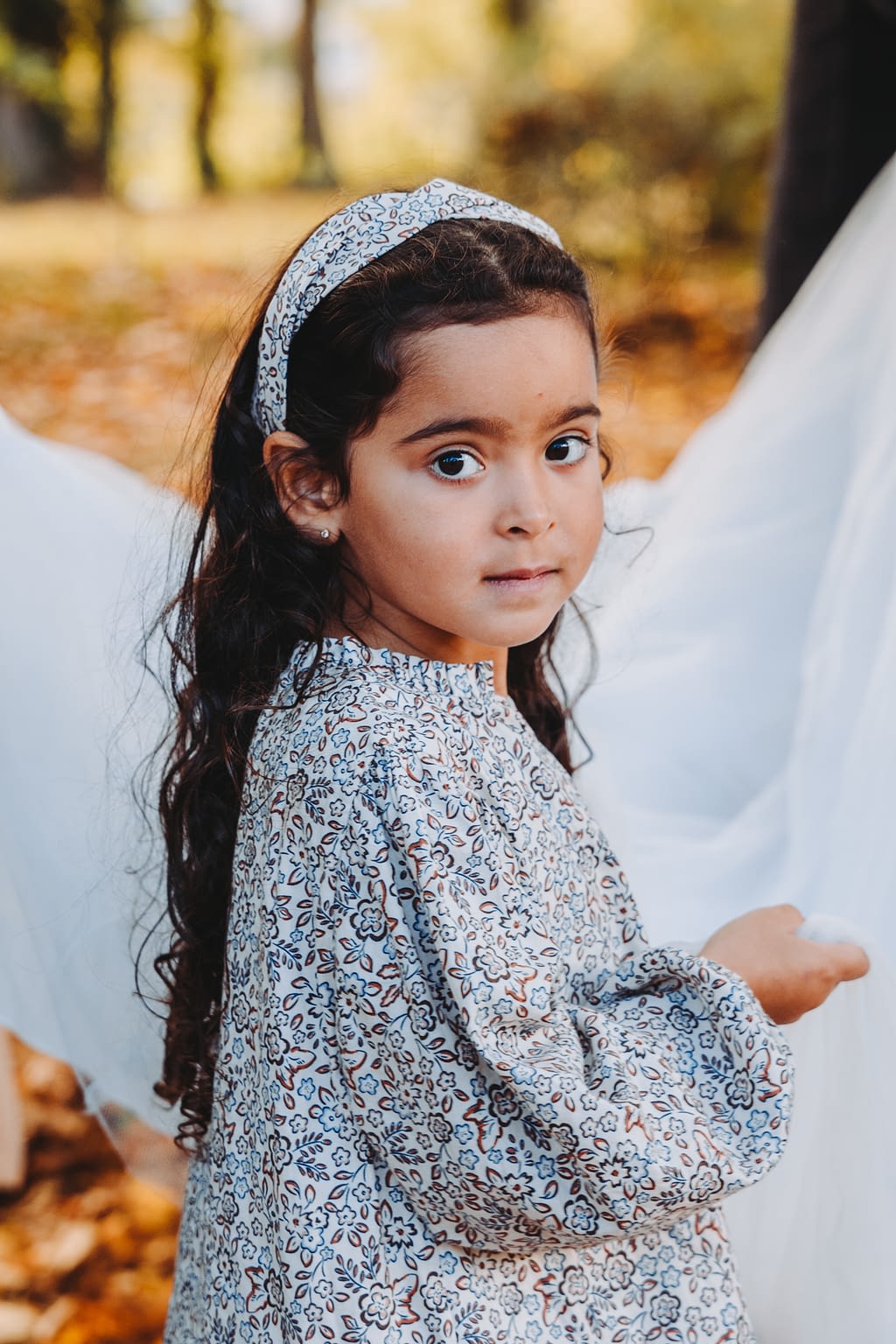 Petite fille qui tient le voile de la robe de mariée