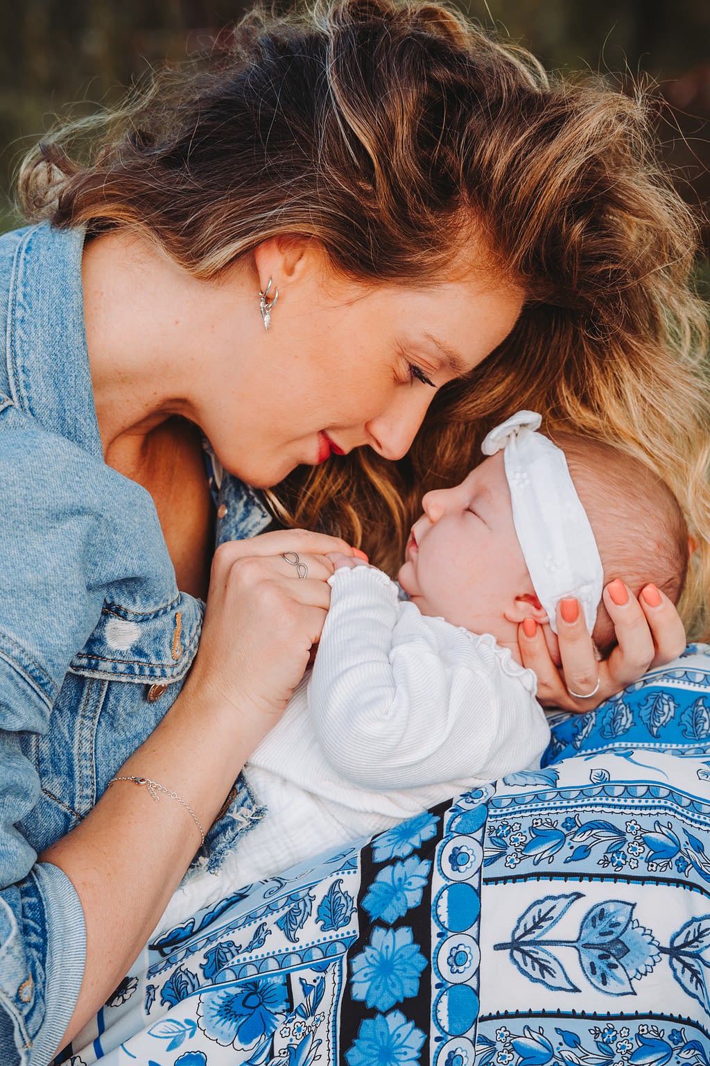Photographie d'une maman et son bébé. Elle le tient face à elle entourée front contre front