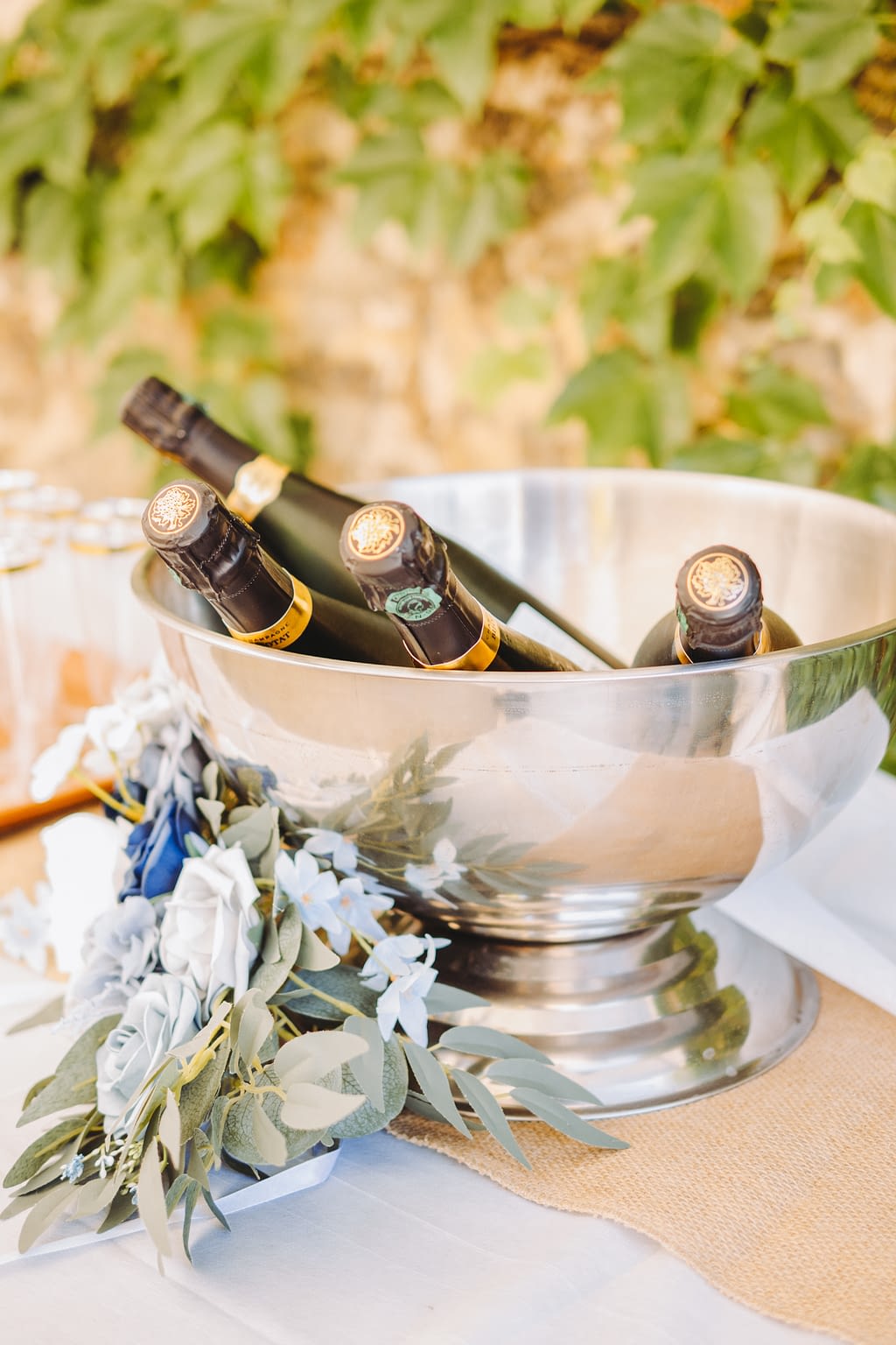 Photographie de décoration de mariage avec bouteilles de champagne et fleurs