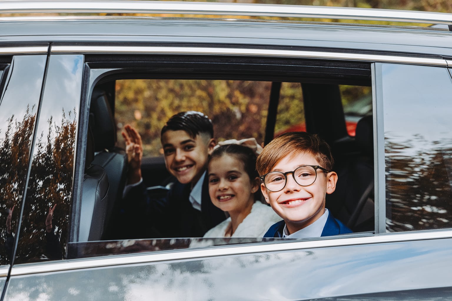Photographie de 3 enfants dans une voiture le jour d'un mariage