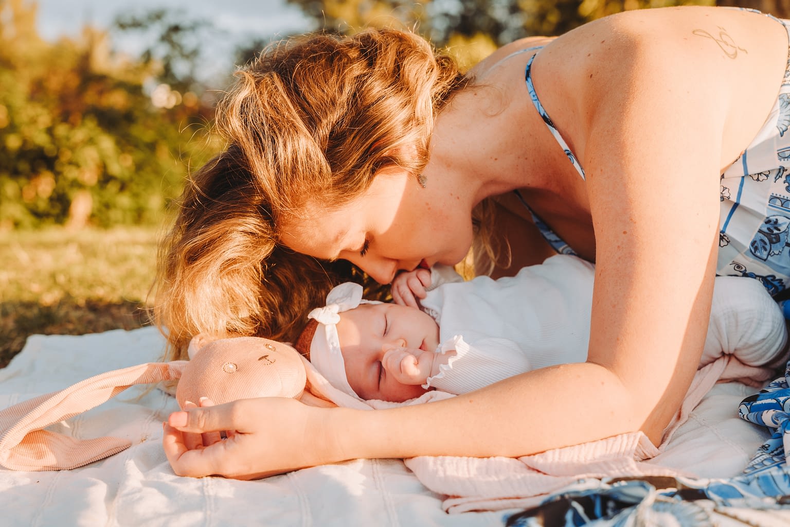 Une maman et son bébé allongée dans un parc.